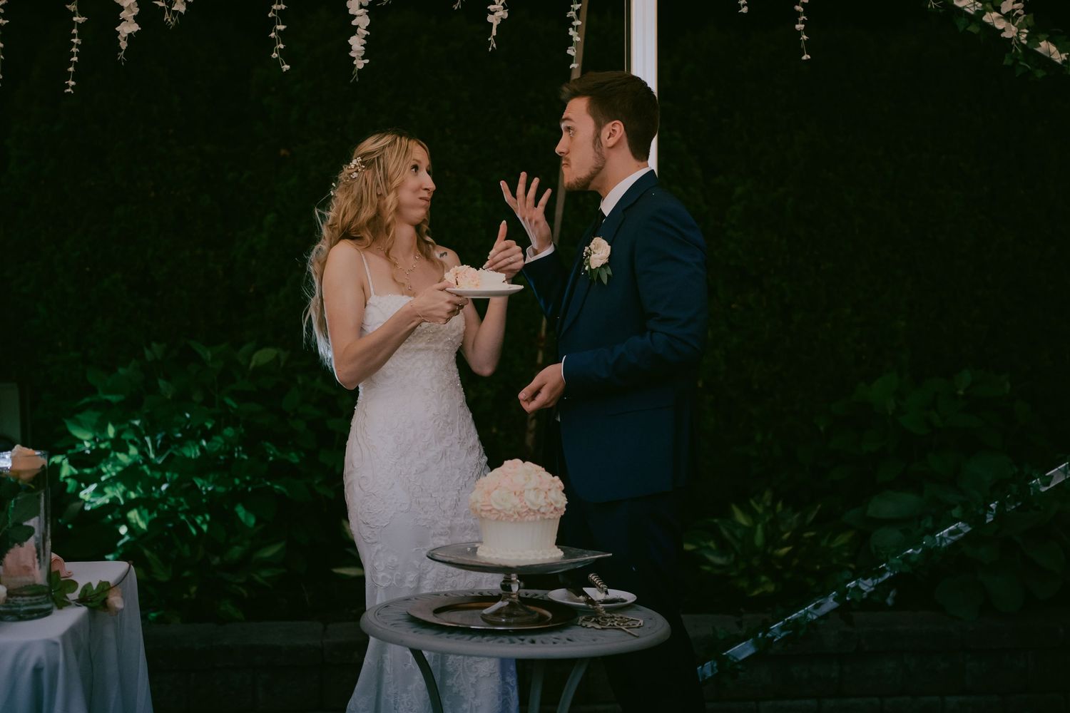 Bride teasing groom during playful wedding cake cutting moment