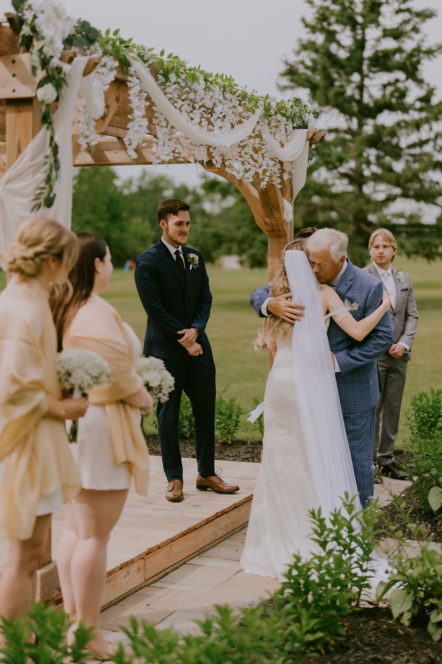 Bride hugging her father at altar during handoff moment