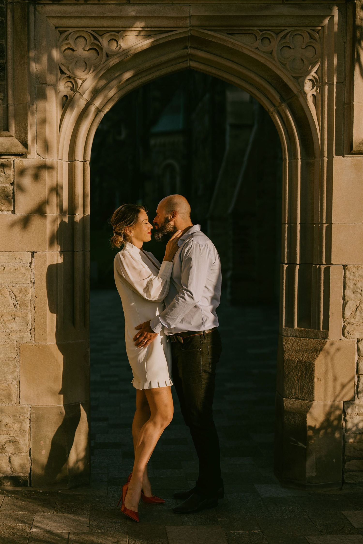 Cinematic engagement photo of couple in a gothic-style arched doorway