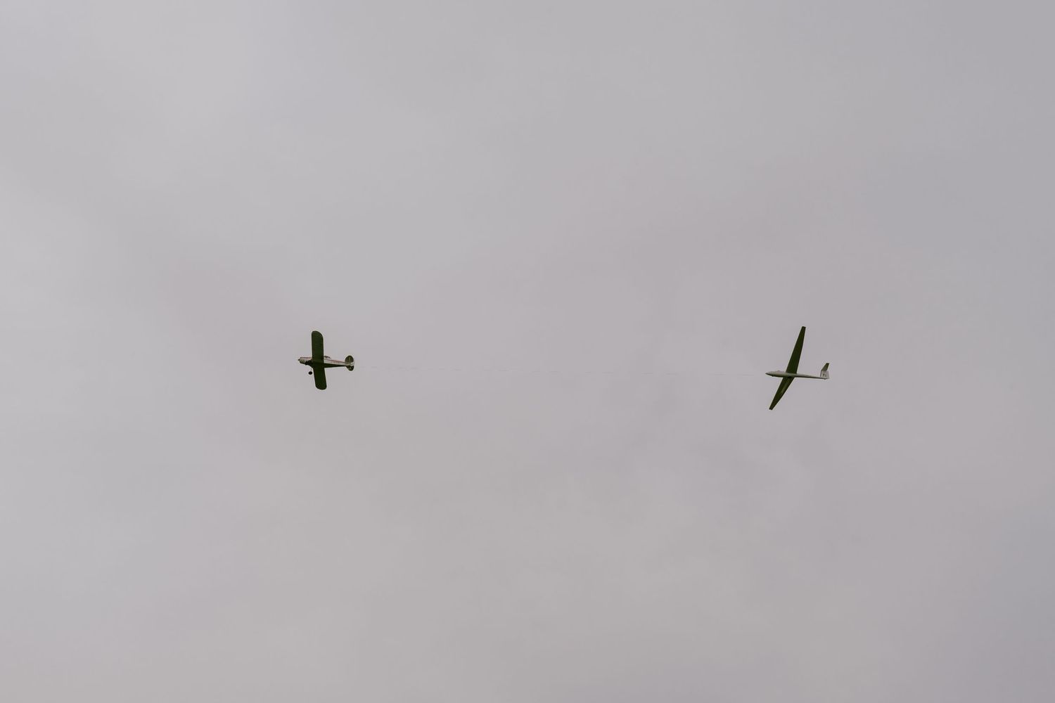 Minimalist image of two vintage airplanes flying in a cloudy sky  in Oshawa, available throughout Toronto and Durham region
