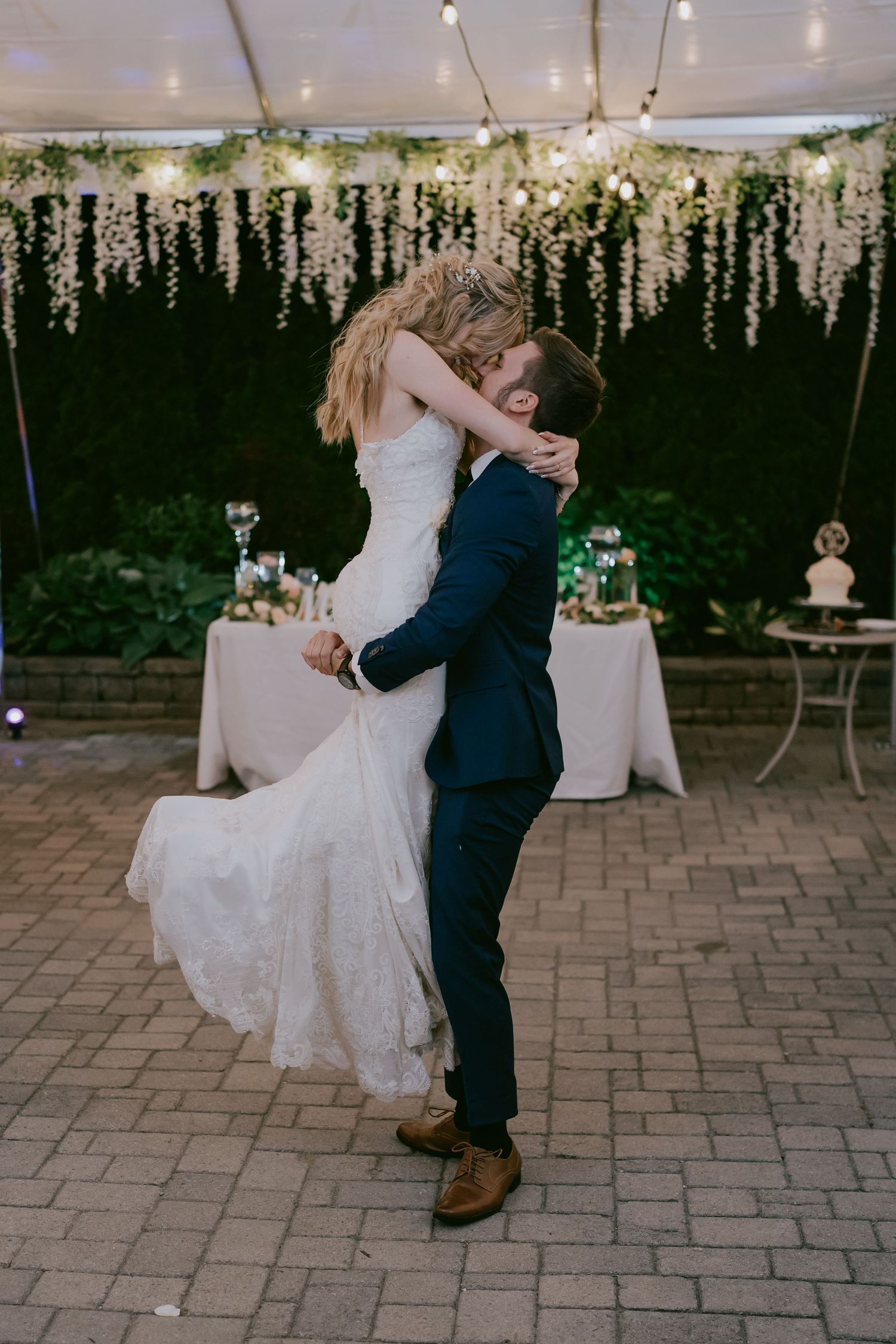 Bride and groom sharing first dance under floral canopy at reception