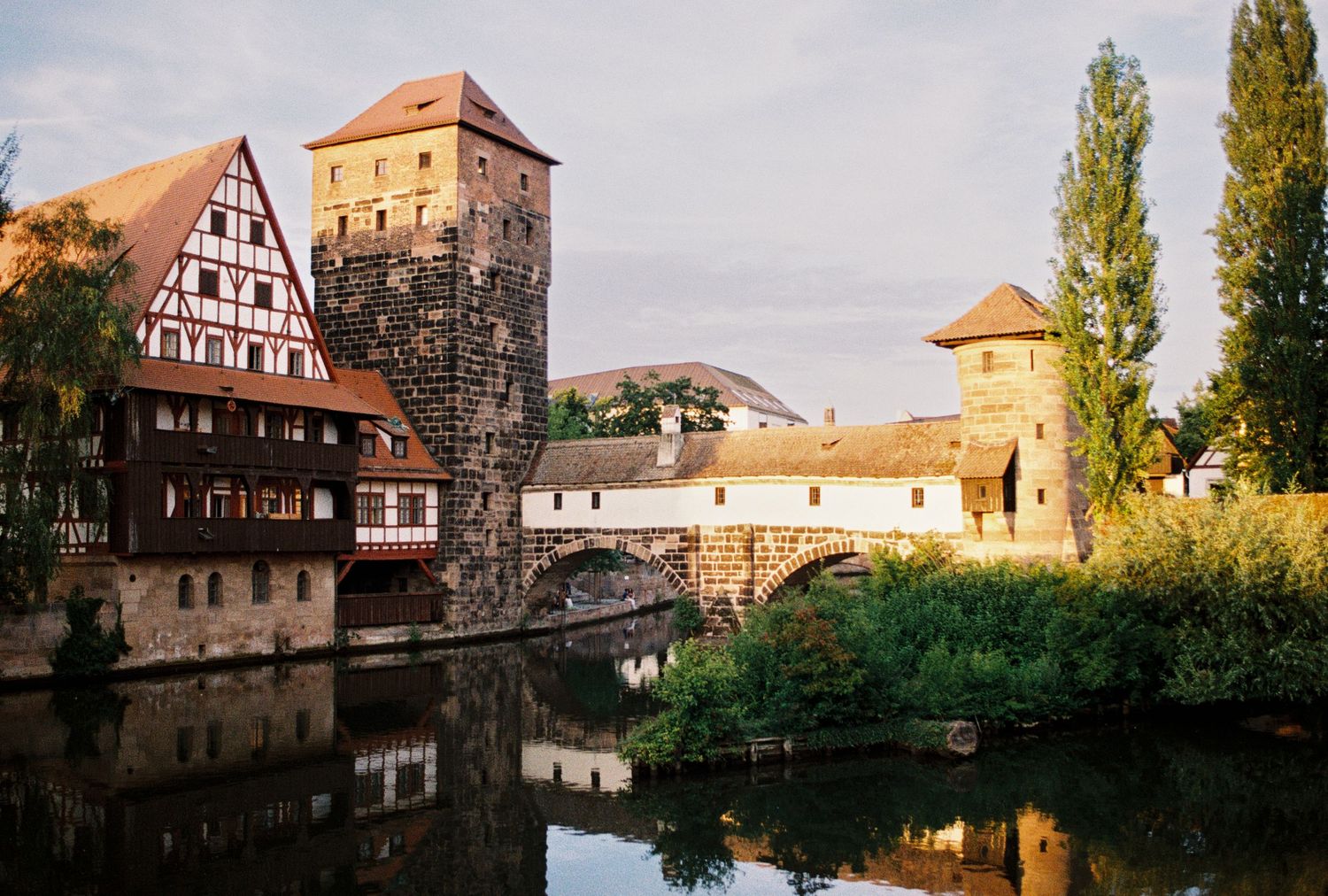 A panoramic view of traditional half-timbered buildings along the river in Nuremberg's historic Old Town district.