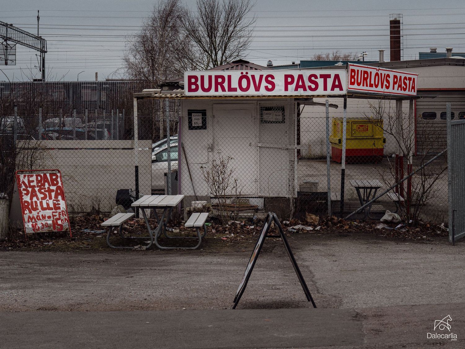 A derelict restaurant with 'Burlovs Pasta' signage stands in a gritty urban setting with debris scattered around.