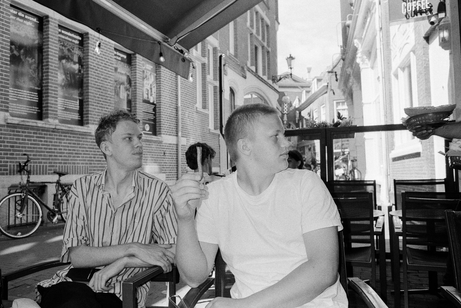 A black and white photo sequence showing diners seated at a casual restaurant having a conversation.