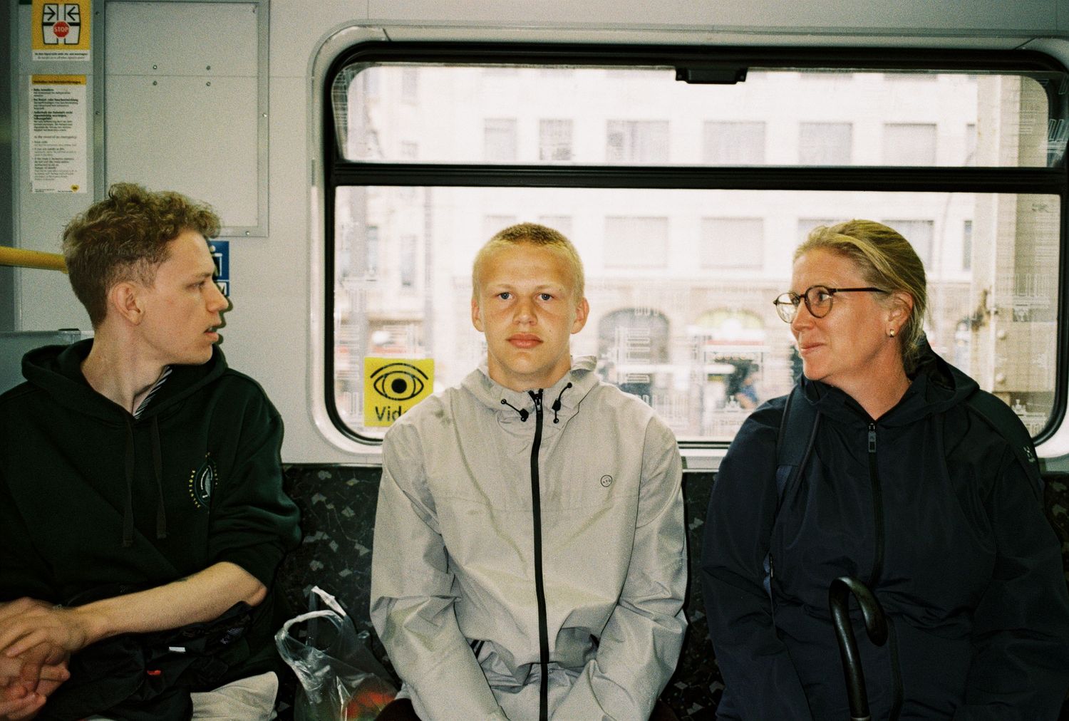Several people sit together inside a train car, having a conversation in a casual atmosphere.