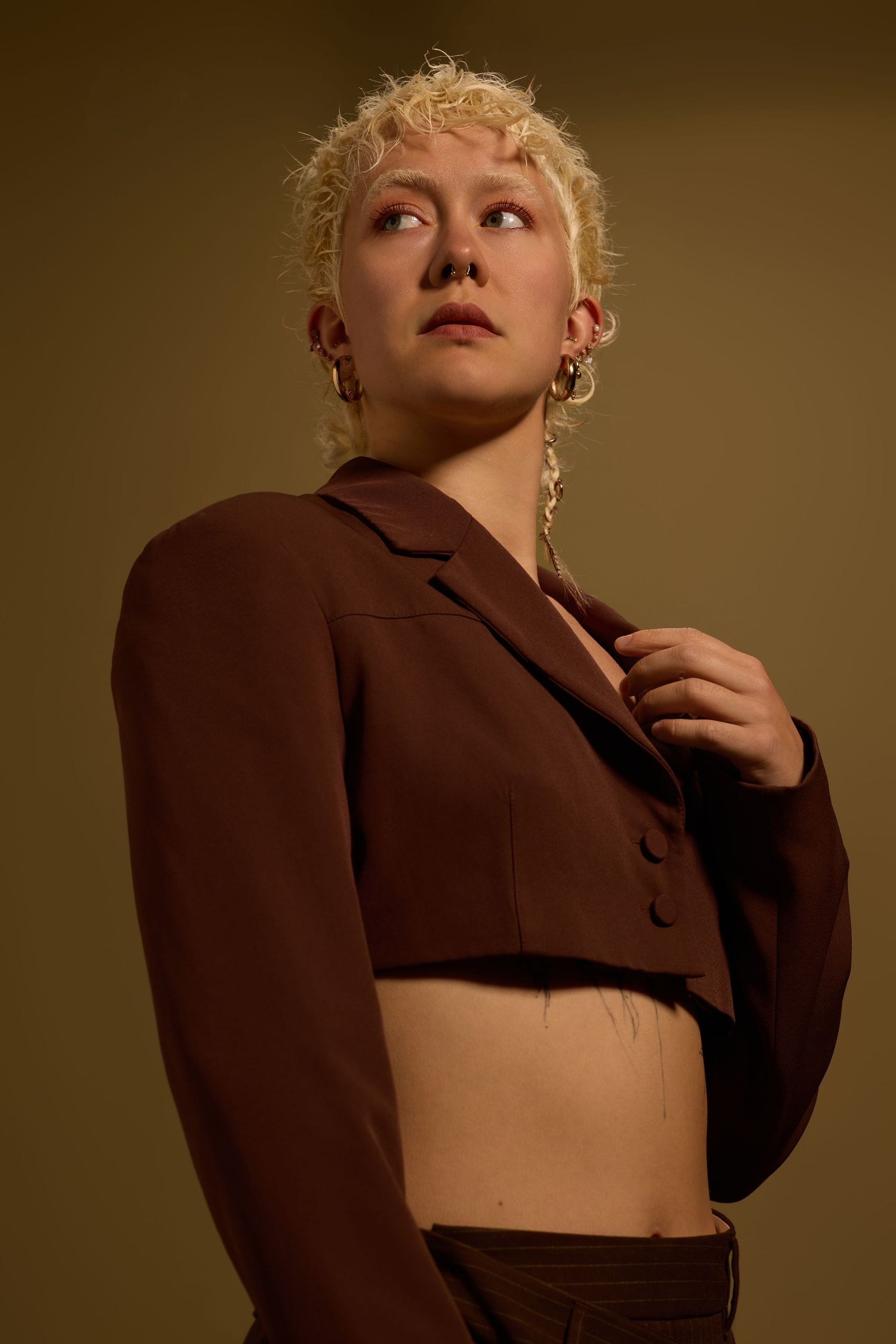 Fashion editorial featuring brown cropped jacket in warm lighting.