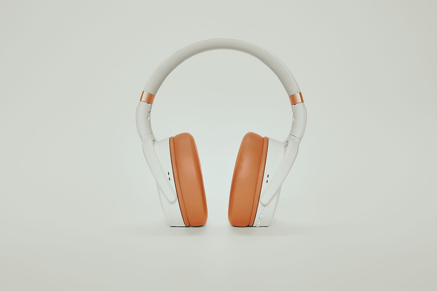 White and tan headphones shown from different angles on a light gray background.