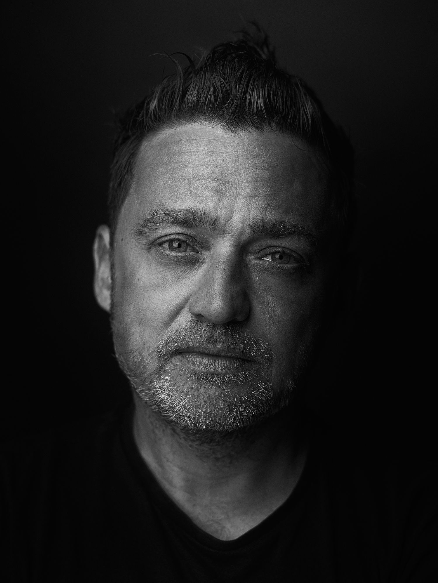 Dramatic black and white portrait series showing different angles of a face in low key lighting.