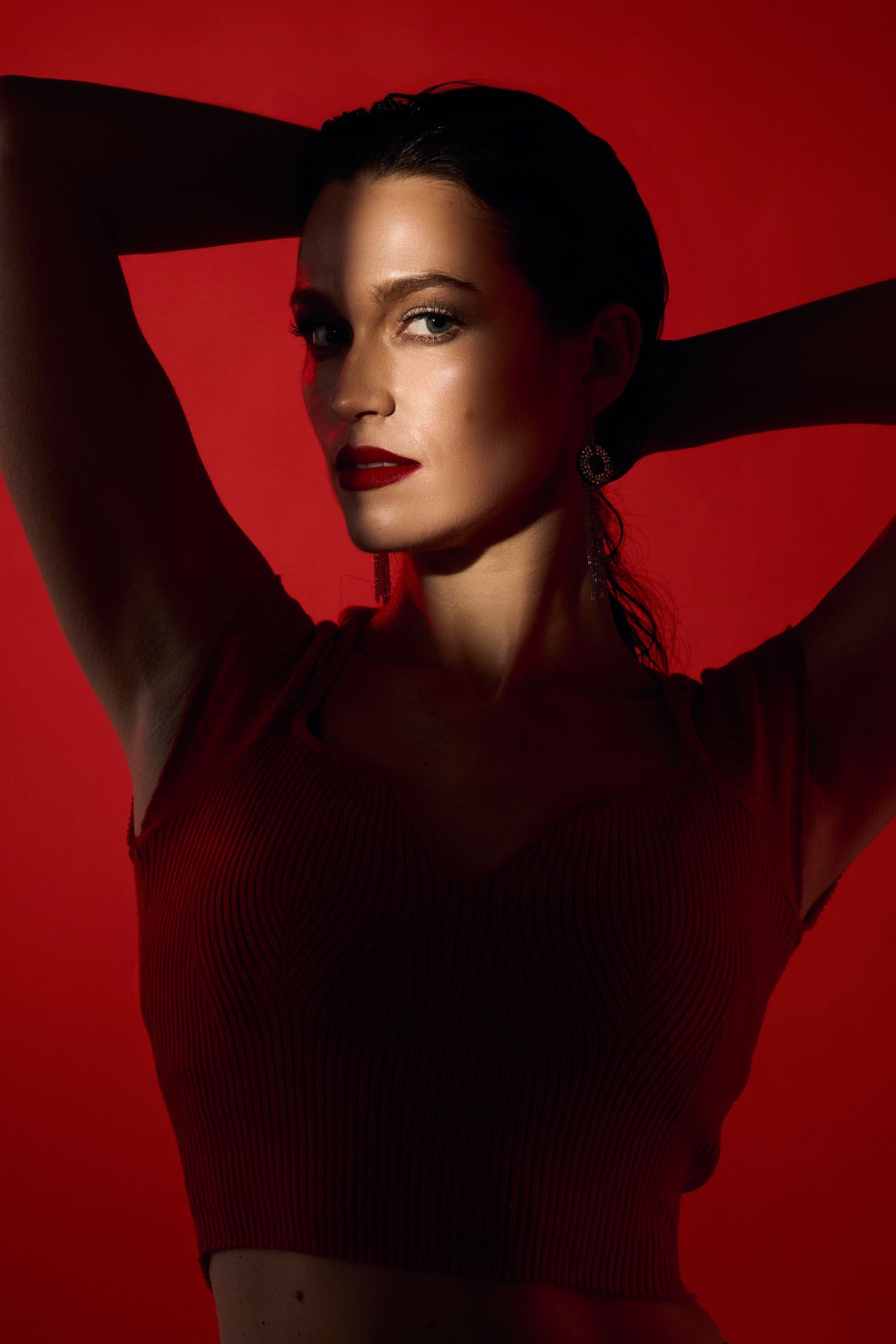 Dramatic silhouette portraits against deep red background with moody lighting.