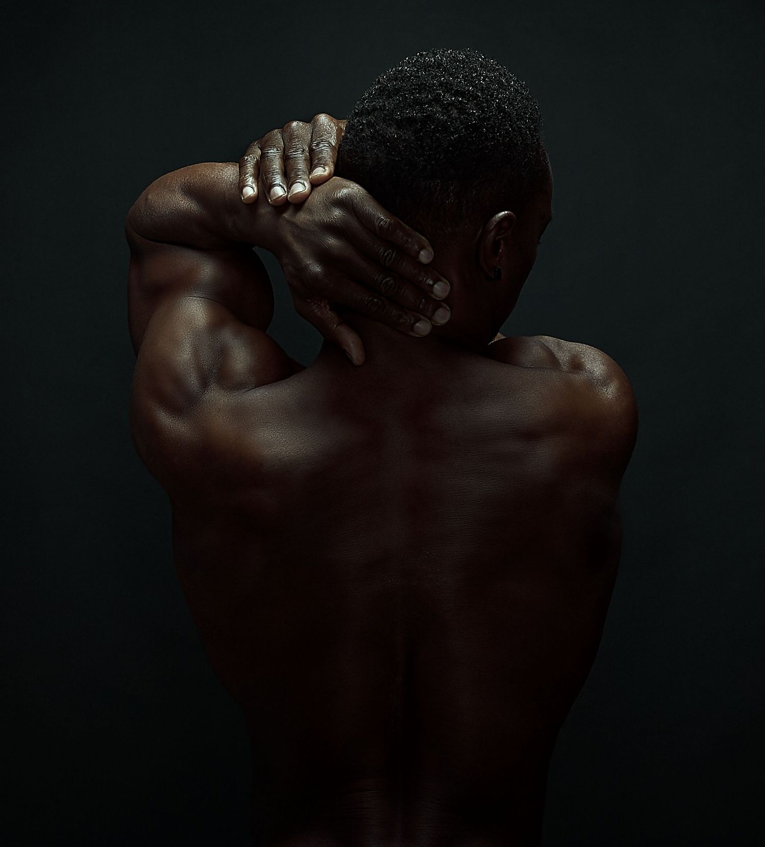 Artistic black and white portrait emphasizing muscular back and shoulders.