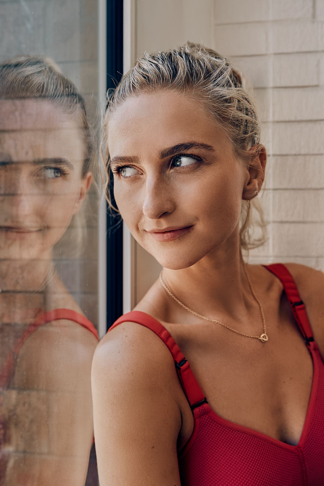 Portrait series through window showing playful expressions in red athletic wear.