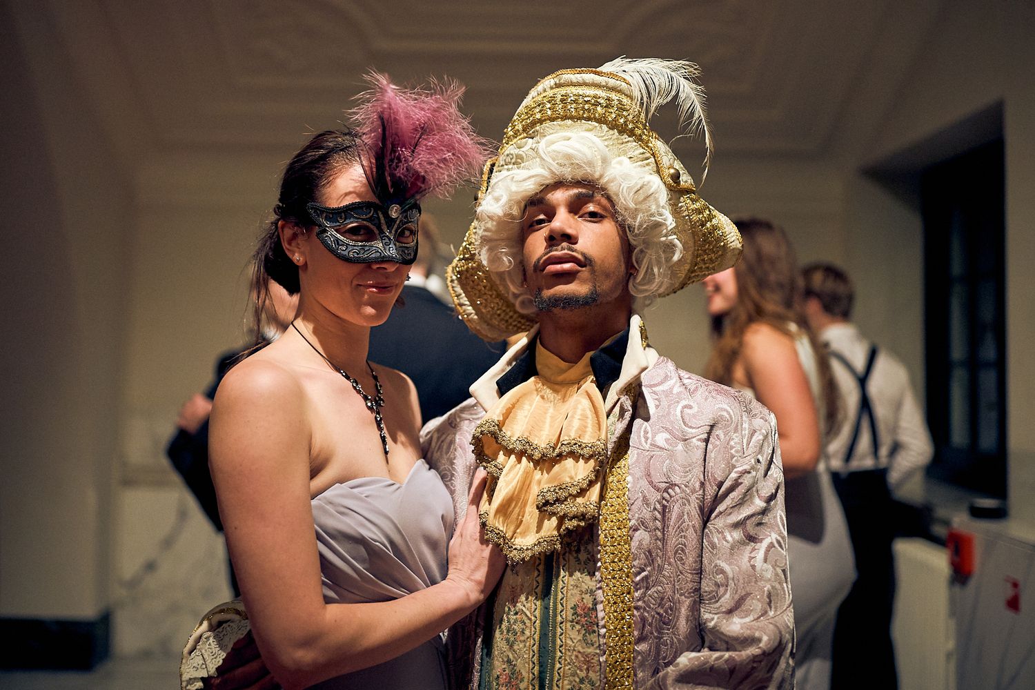 A formal event with attendees dancing and mingling in an elegant indoor venue.