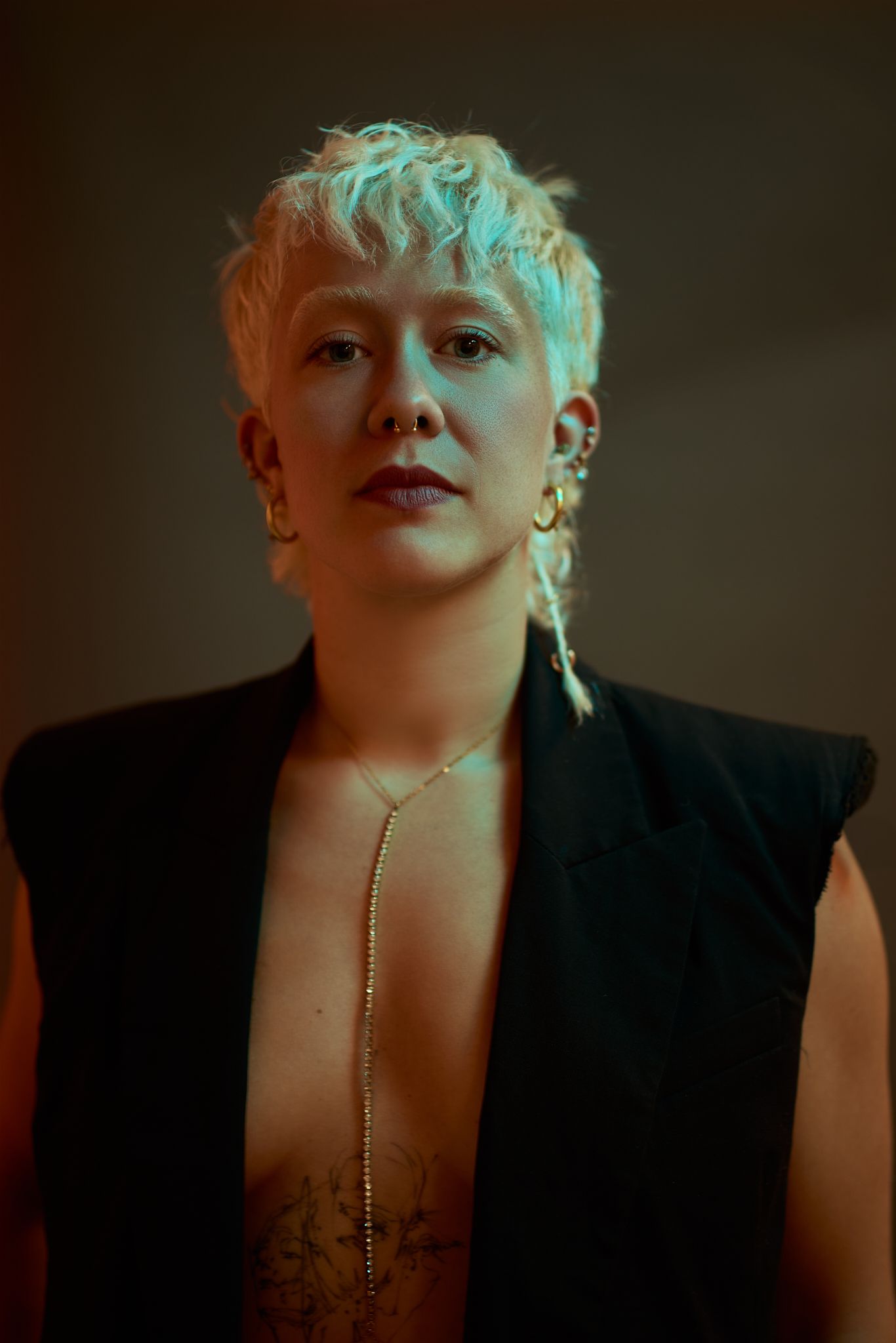Artistic portrait series showing dramatic lighting on figure in black clothing with platinum blonde hair against dark background.