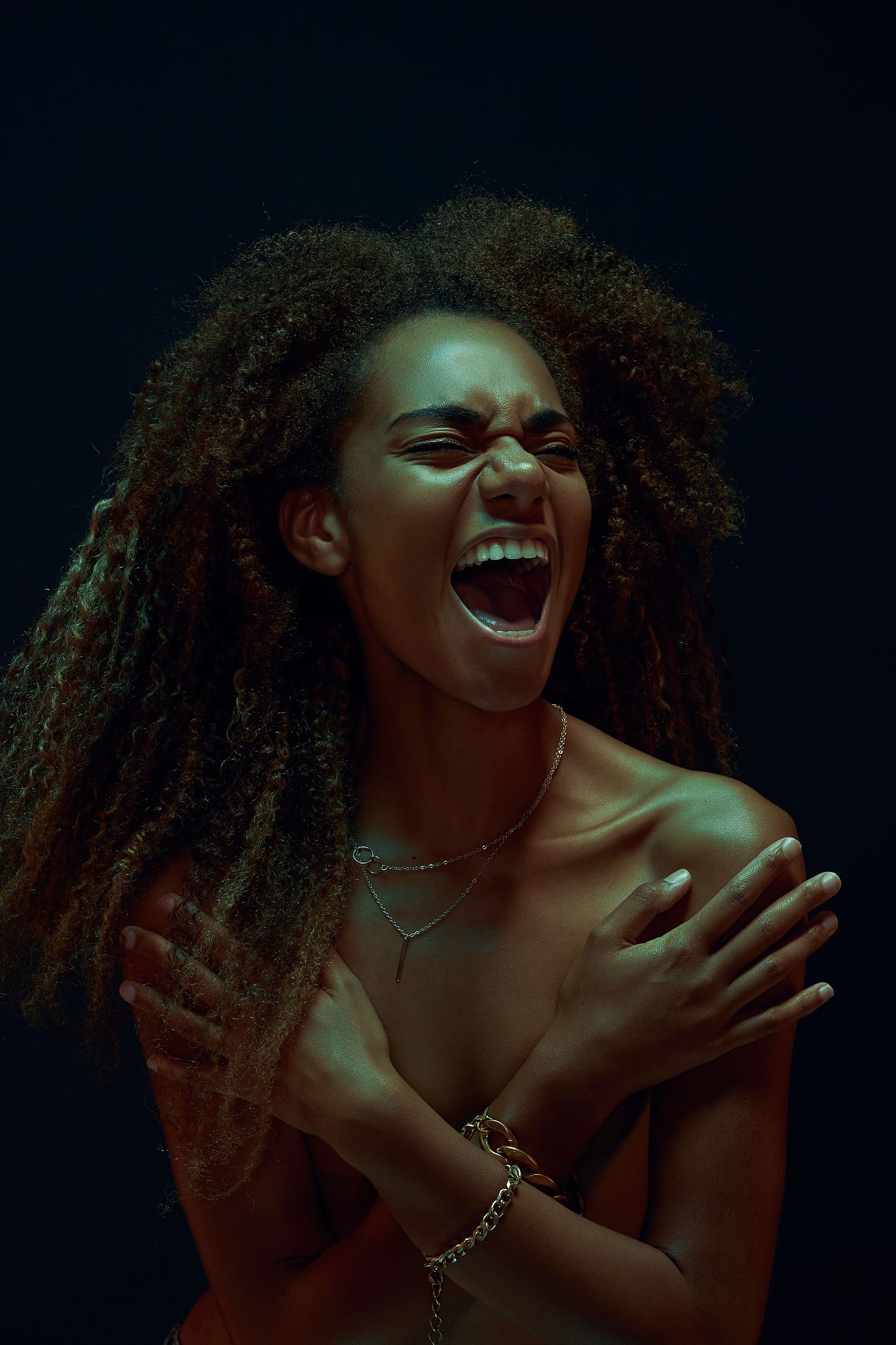 Joyful portrait with natural curly hair captured in expressive laughing poses.