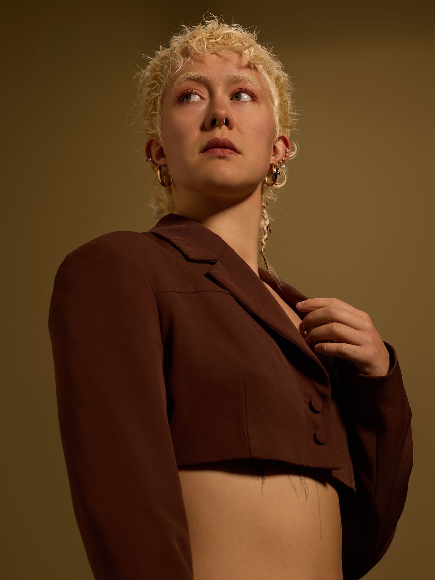Fashion series with brown jacket and artistic poses in studio lighting.