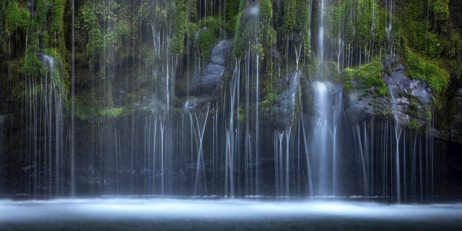 Mossbrae Falls cascading over lush green moss-covered rocks into a serene misty pool in Northern California.