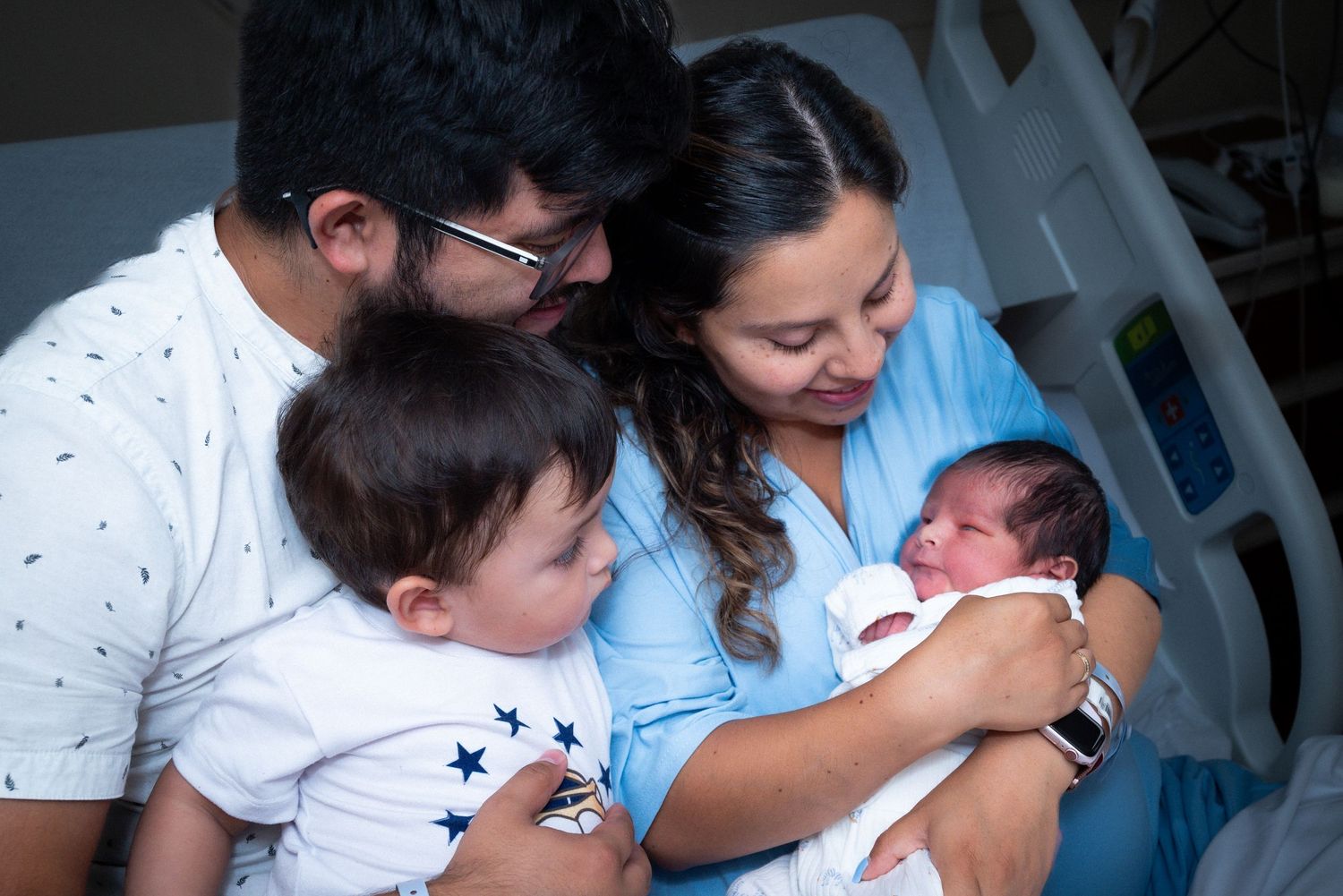 Family gathered together sharing special moments with their newborn. in hospital newborn photography Bowling green ky glasgow ky