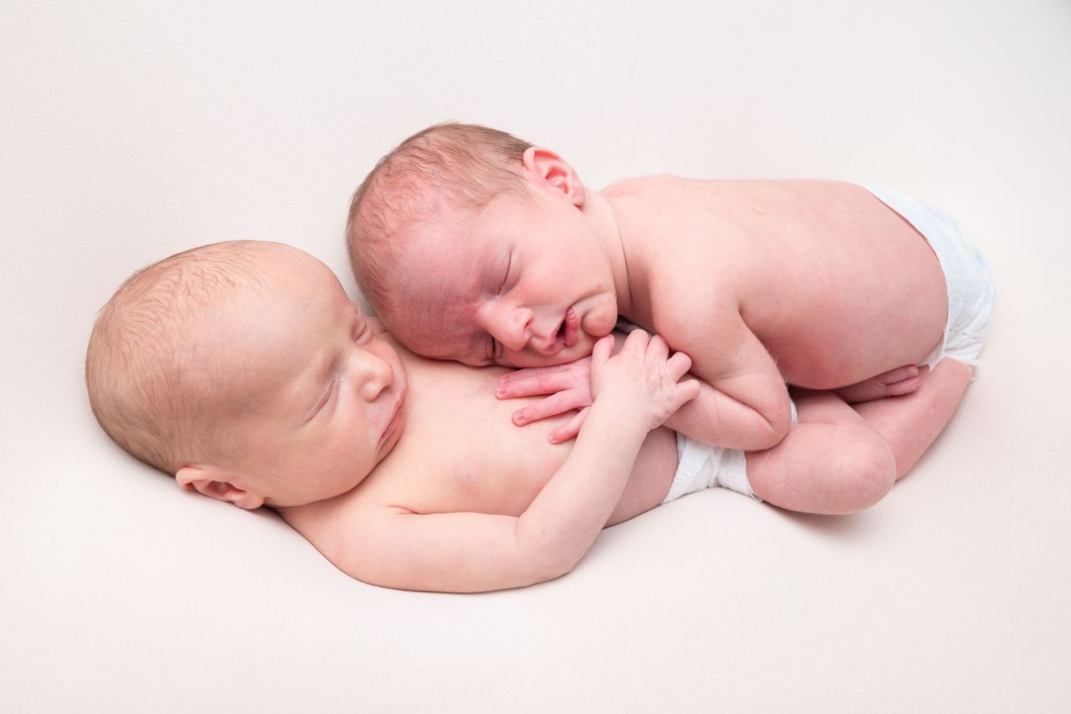 Artistic newborn photography series showing sleeping baby on white background.