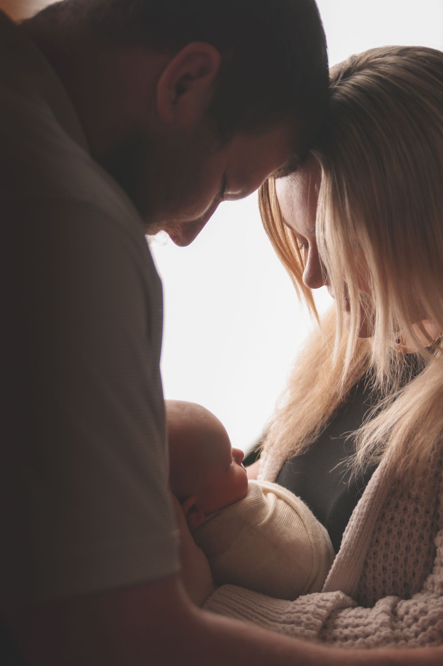 Intimate moment with newborn baby captured in soft lighting. Studio photography franklin ky SOKY