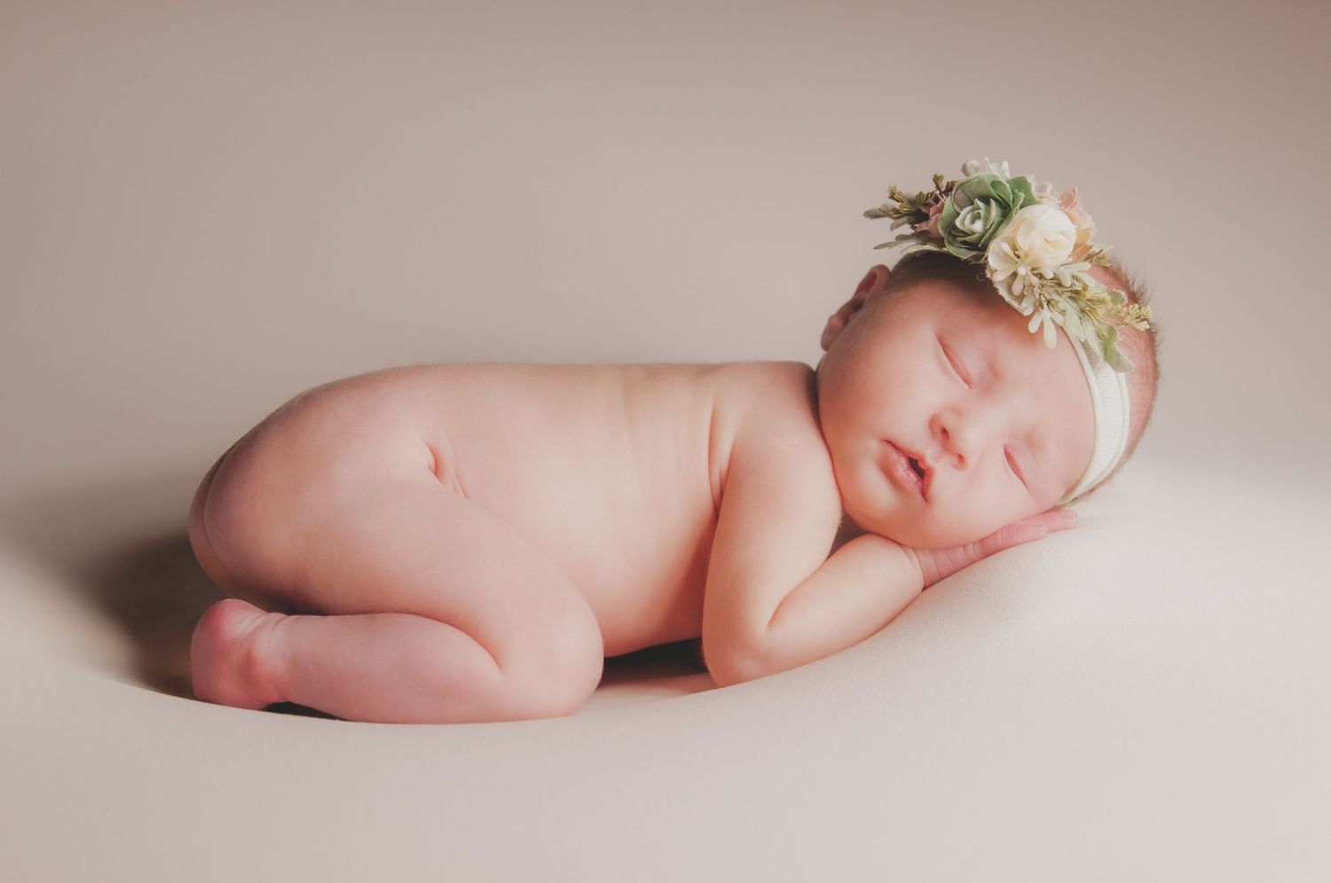 Artistic newborn portrait with delicate floral headpiece against neutral backdrop. Studio photography franklin ky SOKY