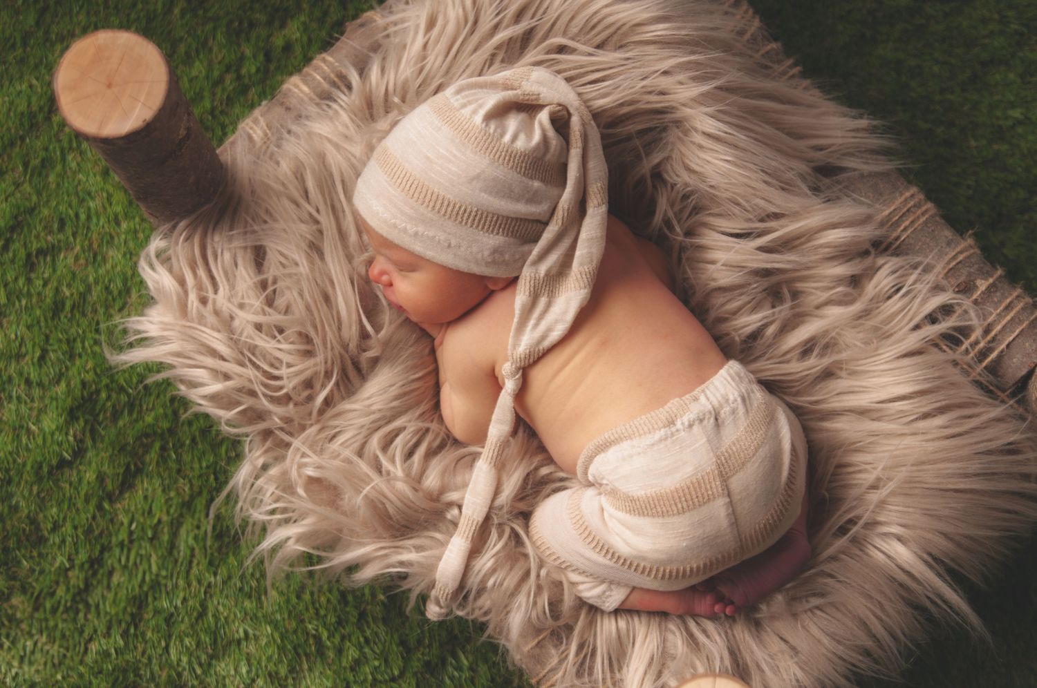 Newborn baby sleeps on furry blanket outdoors with soft lighting. Studio photography franklin ky SOKY