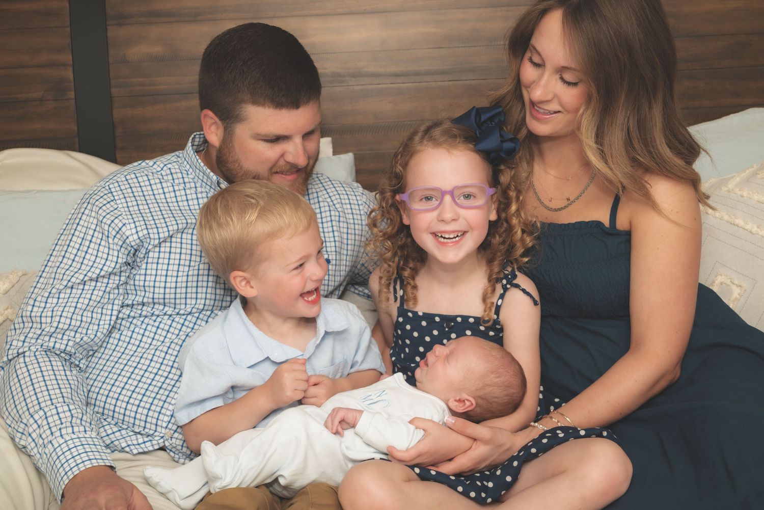 Family sharing tender moments together on a couch with their newborn baby. in home photography Bowling Green ky franklin ky