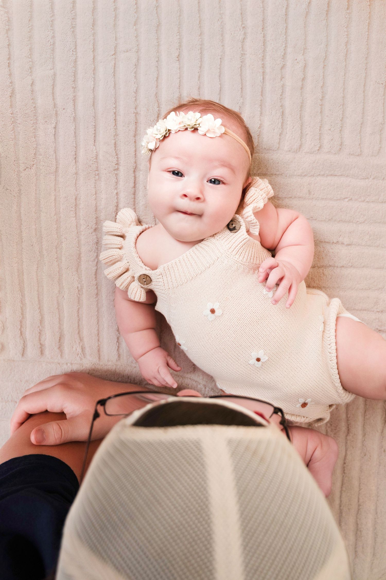 Baby milestone photos showing infant in cream-colored outfit on textured background. Studio Milestone Photos Franklin KY