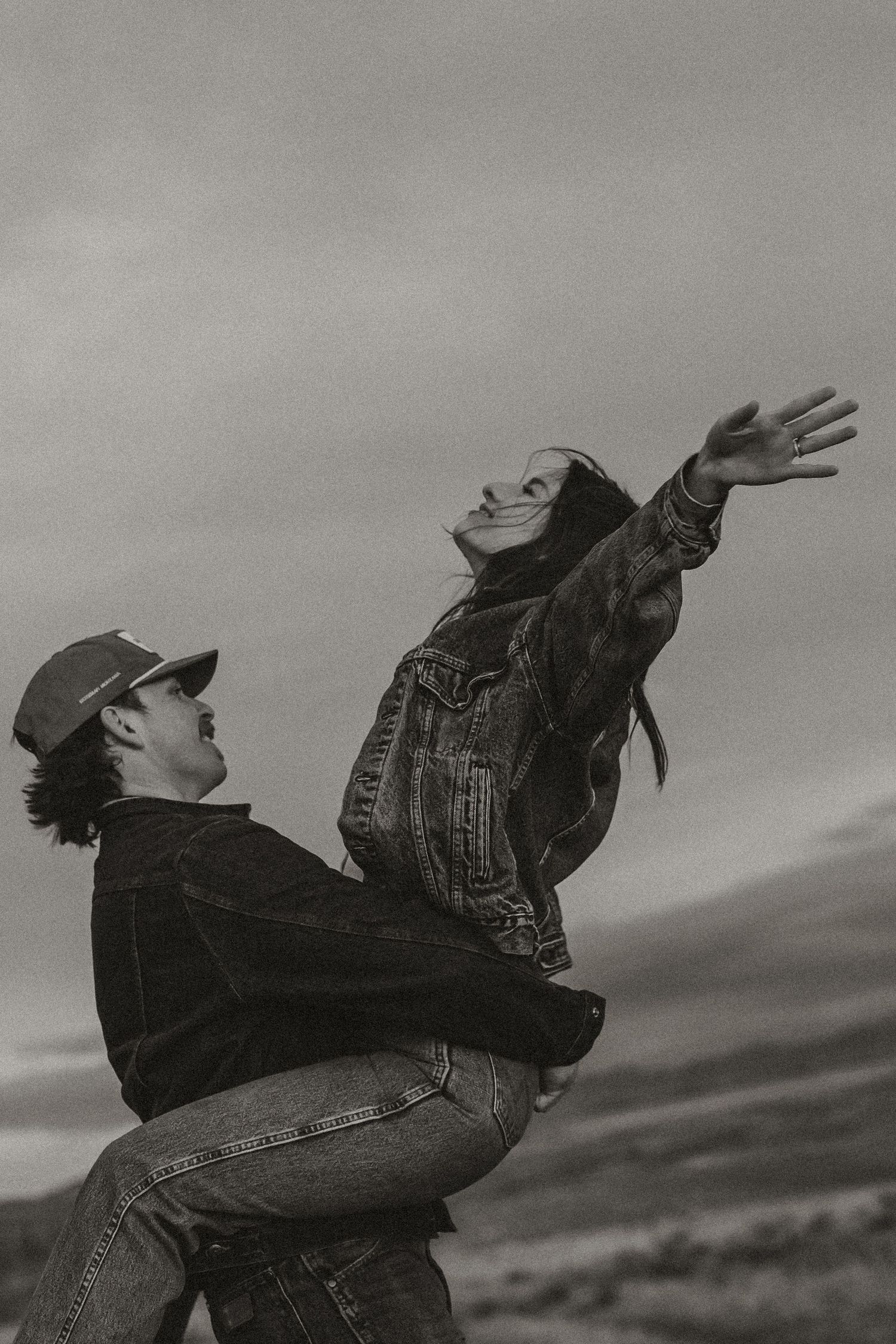 A black and white sequence shows a person in denim falling backwards in dramatic motion against a cloudy sky.