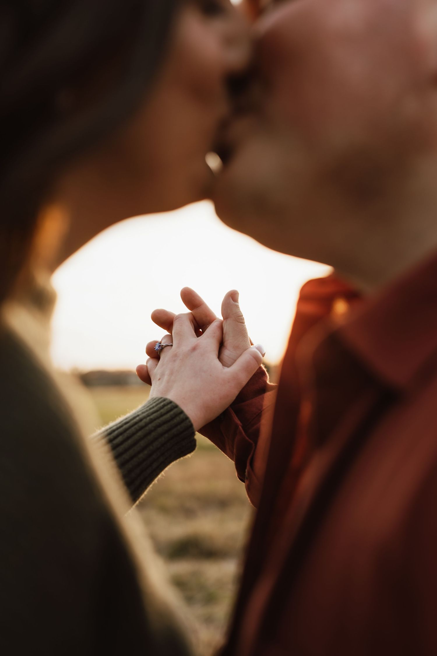 Hands in prayer position against a dark background with soft lighting and shallow depth of field.