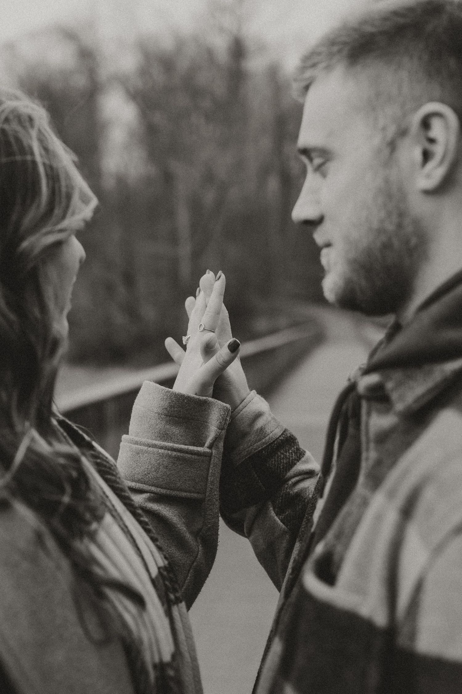 A black and white photo sequence showing two people in winter coats sharing a tender moment outdoors.
