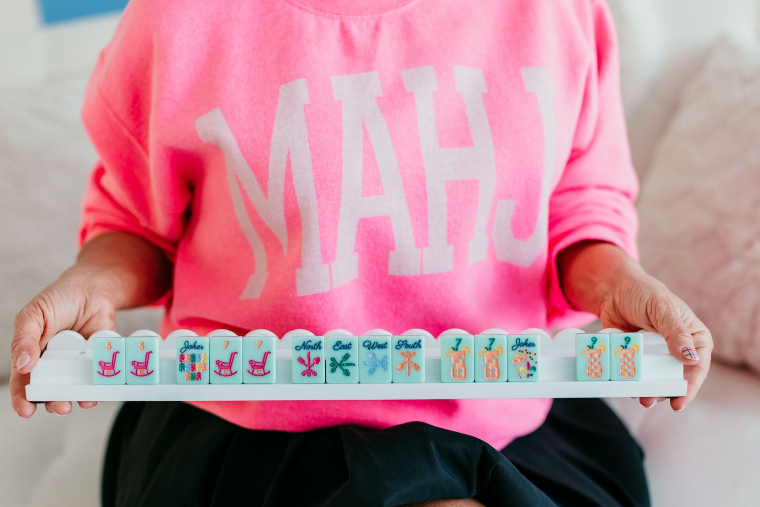 Pink mahjong tile rack held against a bright pink shirt.