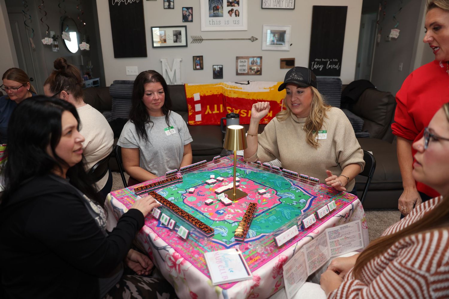 A group of people gathered around a table playing a board game together in a social setting.
