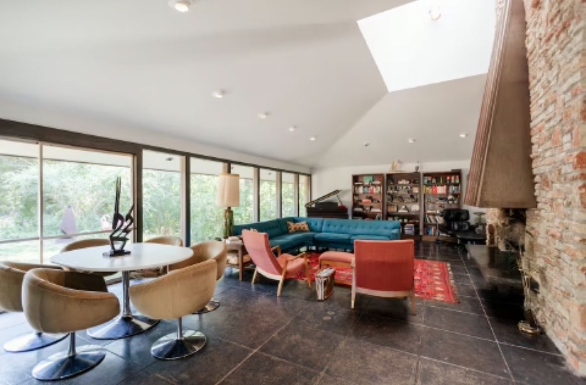 Modern interior space with brick walls, skylights, and contemporary furniture layout.