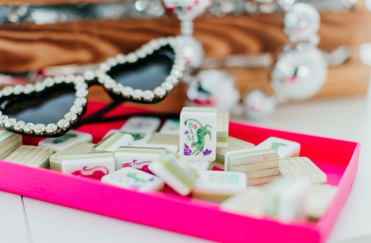 Sparkling crystal necklaces and jewelry pieces displayed on bright pink and brown surfaces with soft lighting.