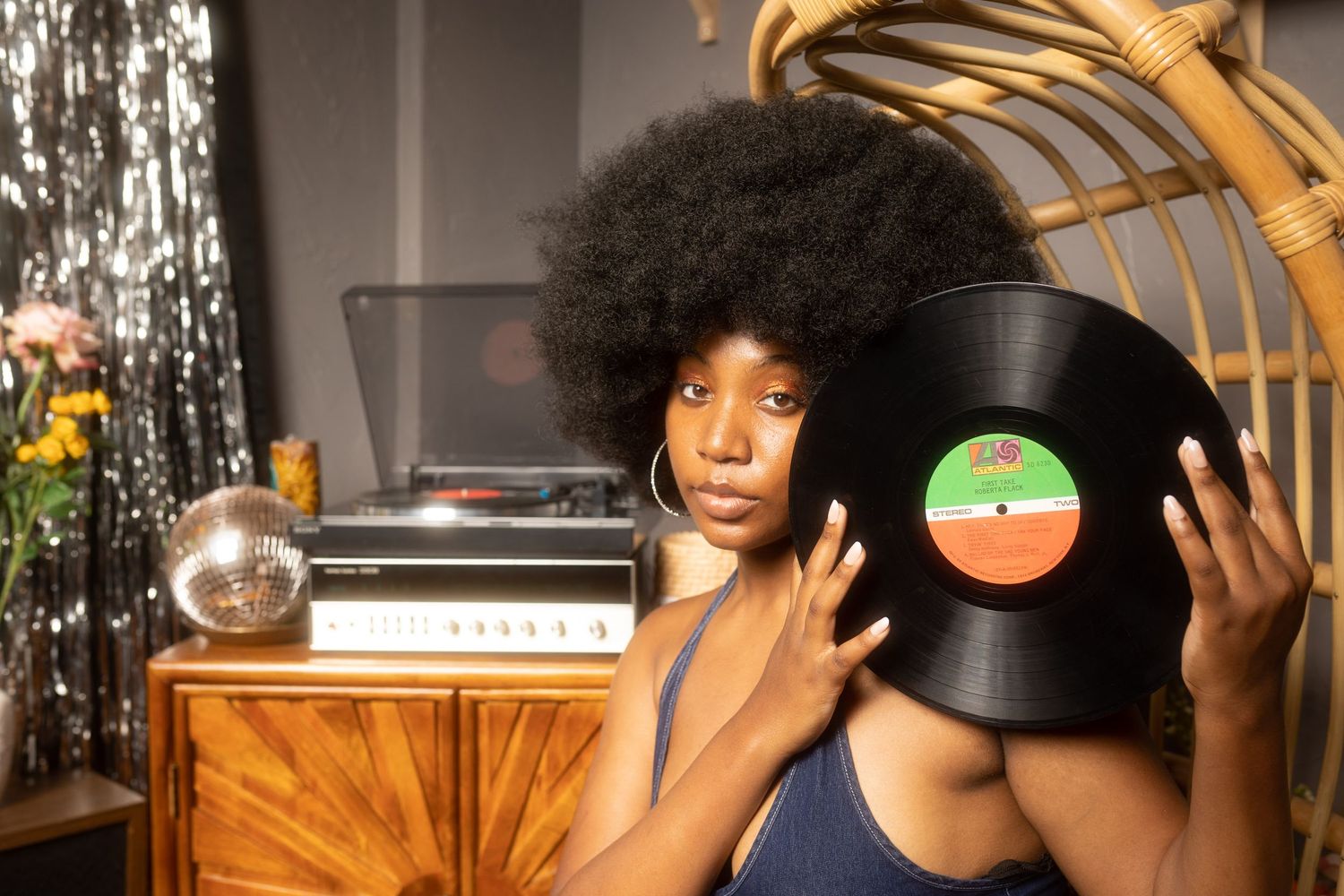 Artistic photoshoot with vinyl records and vintage wooden furniture.