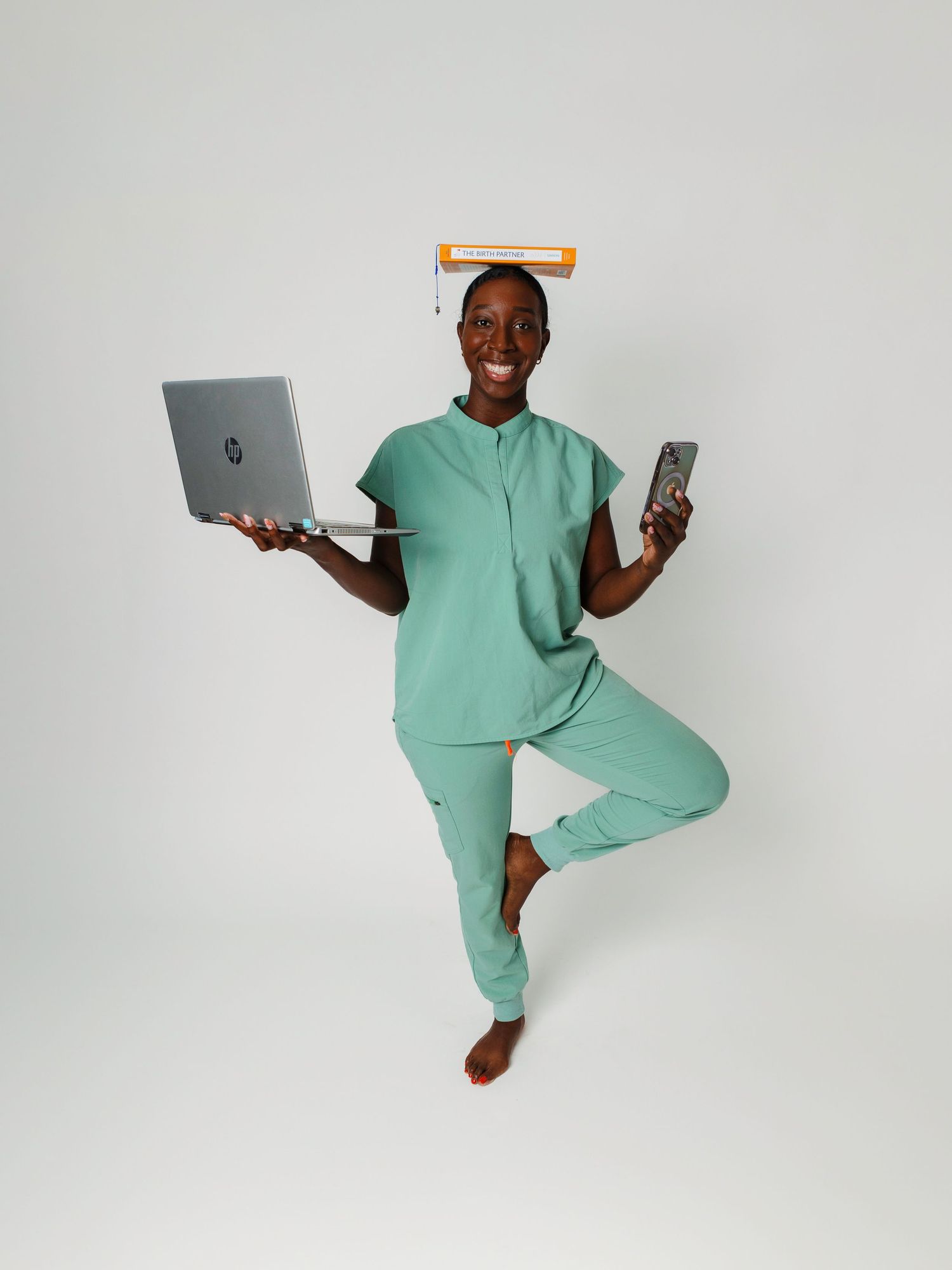 Person in mint loungewear demonstrates yoga poses while holding electronic devices.