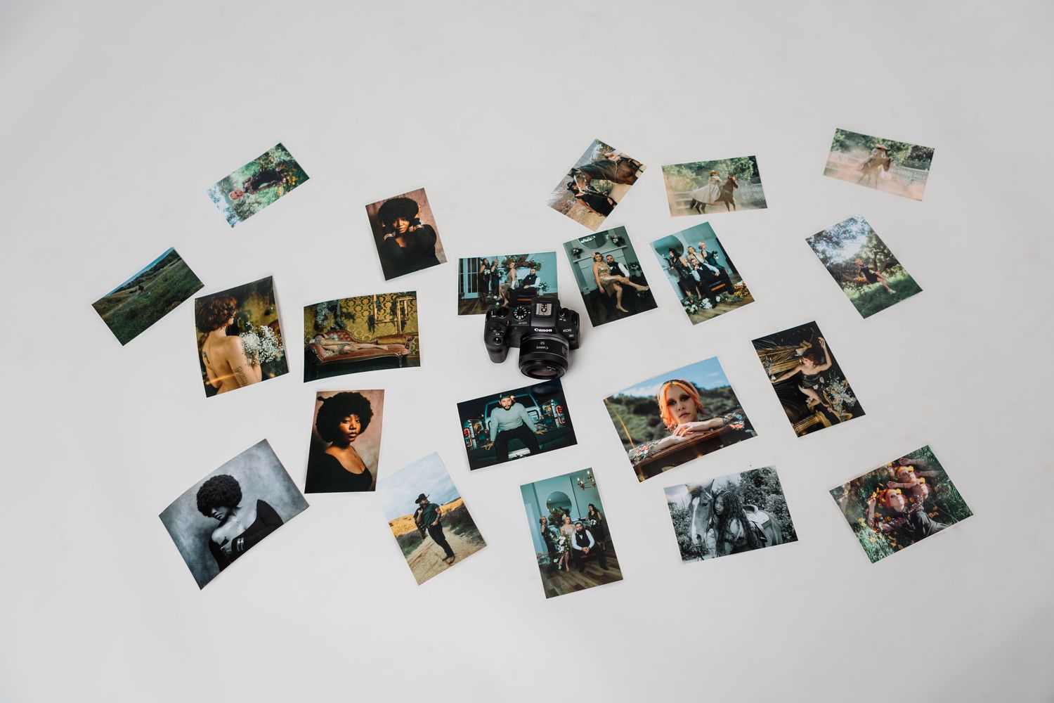 A collection of scattered printed photos spread across a white surface, showcasing various travel and portrait images.