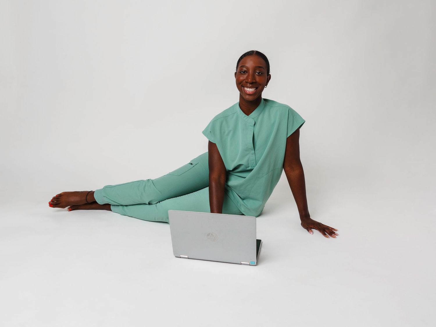 Model in mint green outfit posing against white studio background.