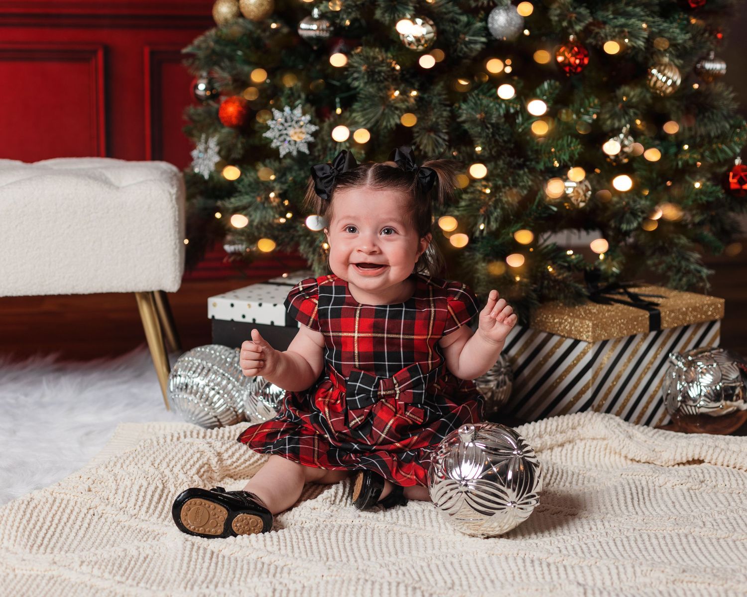 Christmas themed photo setup with decorated tree, ornaments, and textured carpet.