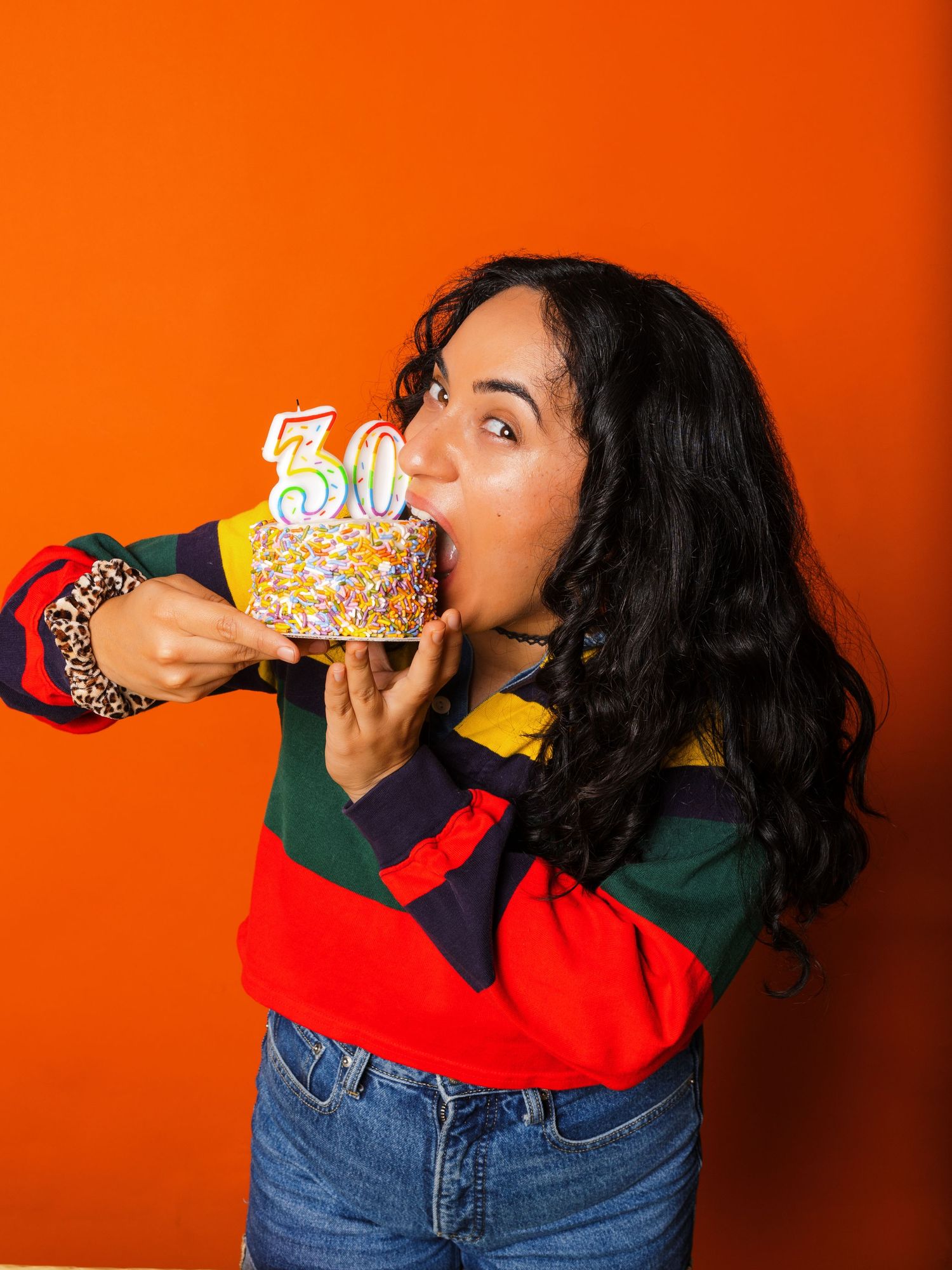 Playful sequence showing someone eating birthday cake against vibrant orange wall.