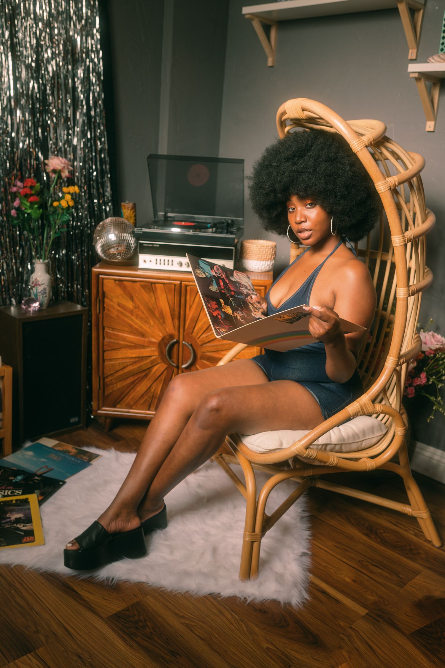 Stylish room setup with rattan furniture and vintage record player cabinet.