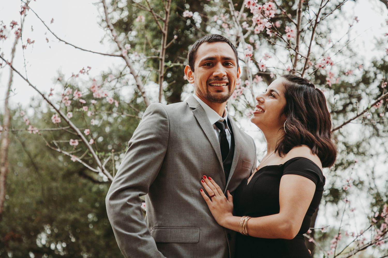Happy couple laughing and embracing during outdoor photo session.