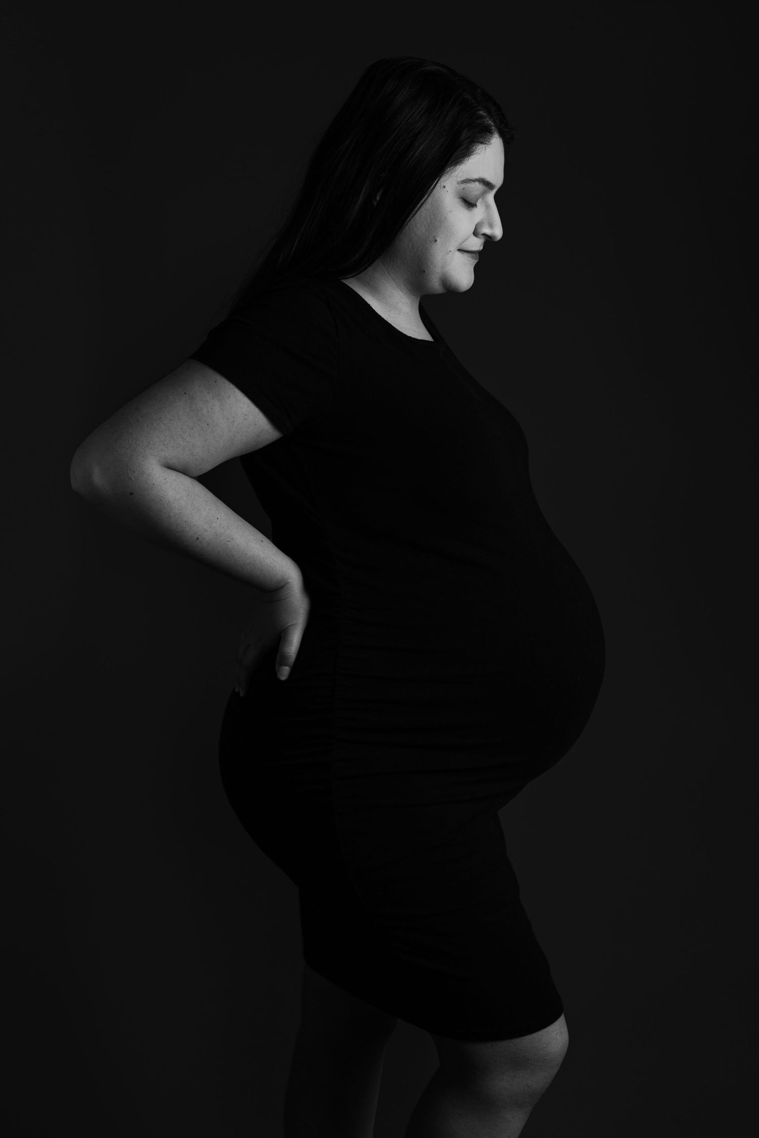 Artistic black and white profile silhouette against dark background.