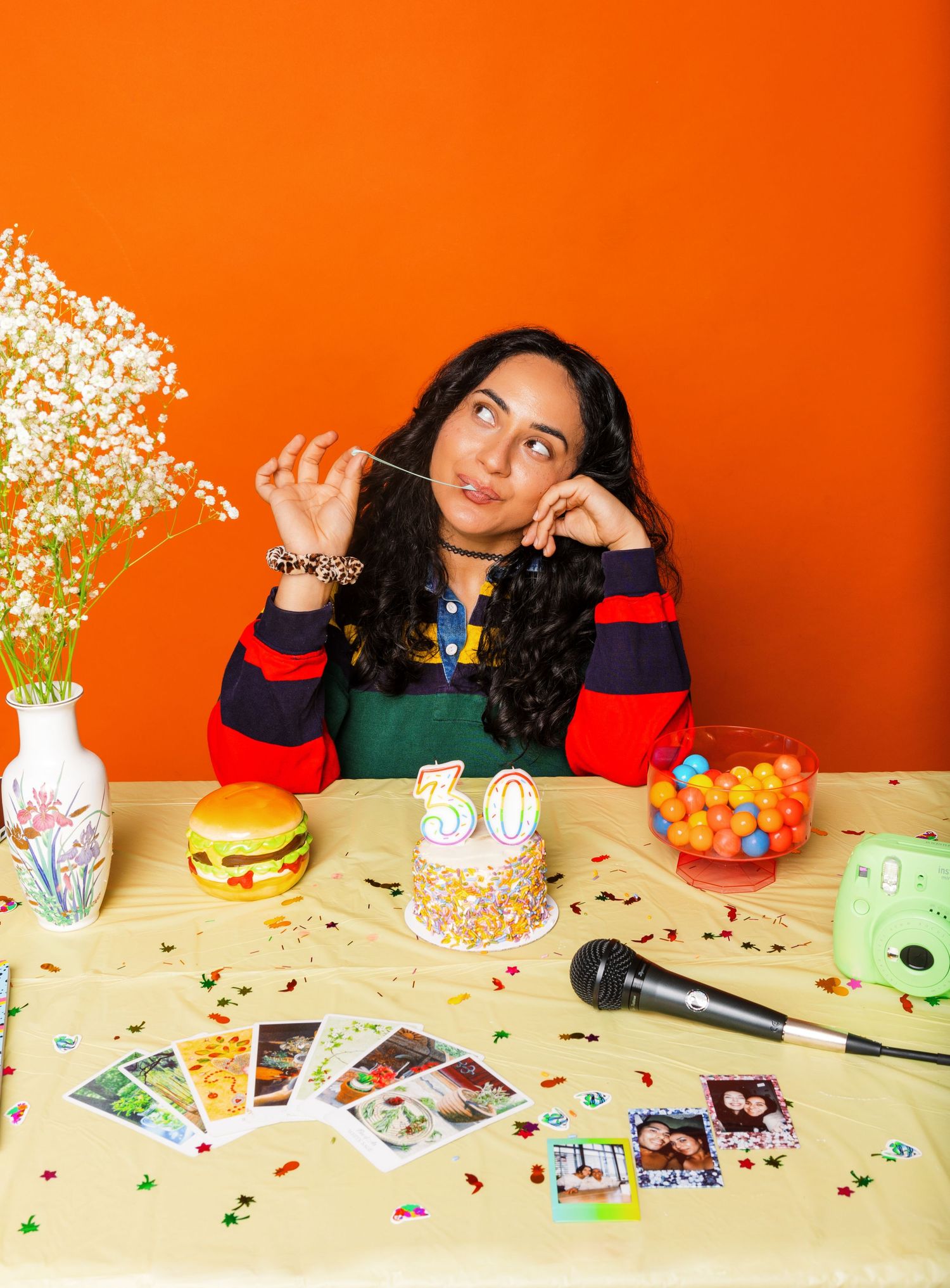 Festive party setup with snacks and decorations against bright orange background.