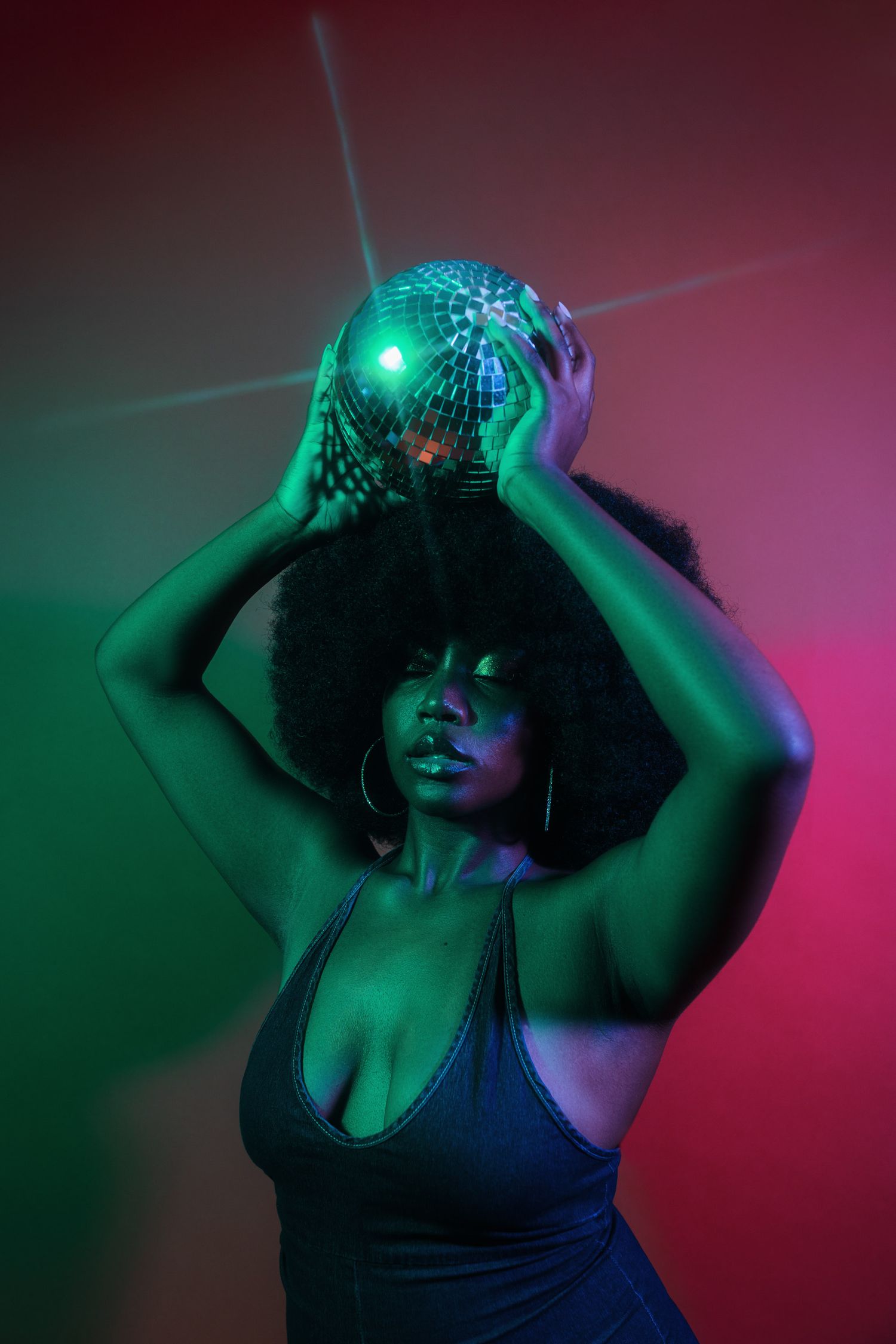 Disco ball photoshoot with dramatic green and pink lighting effects.