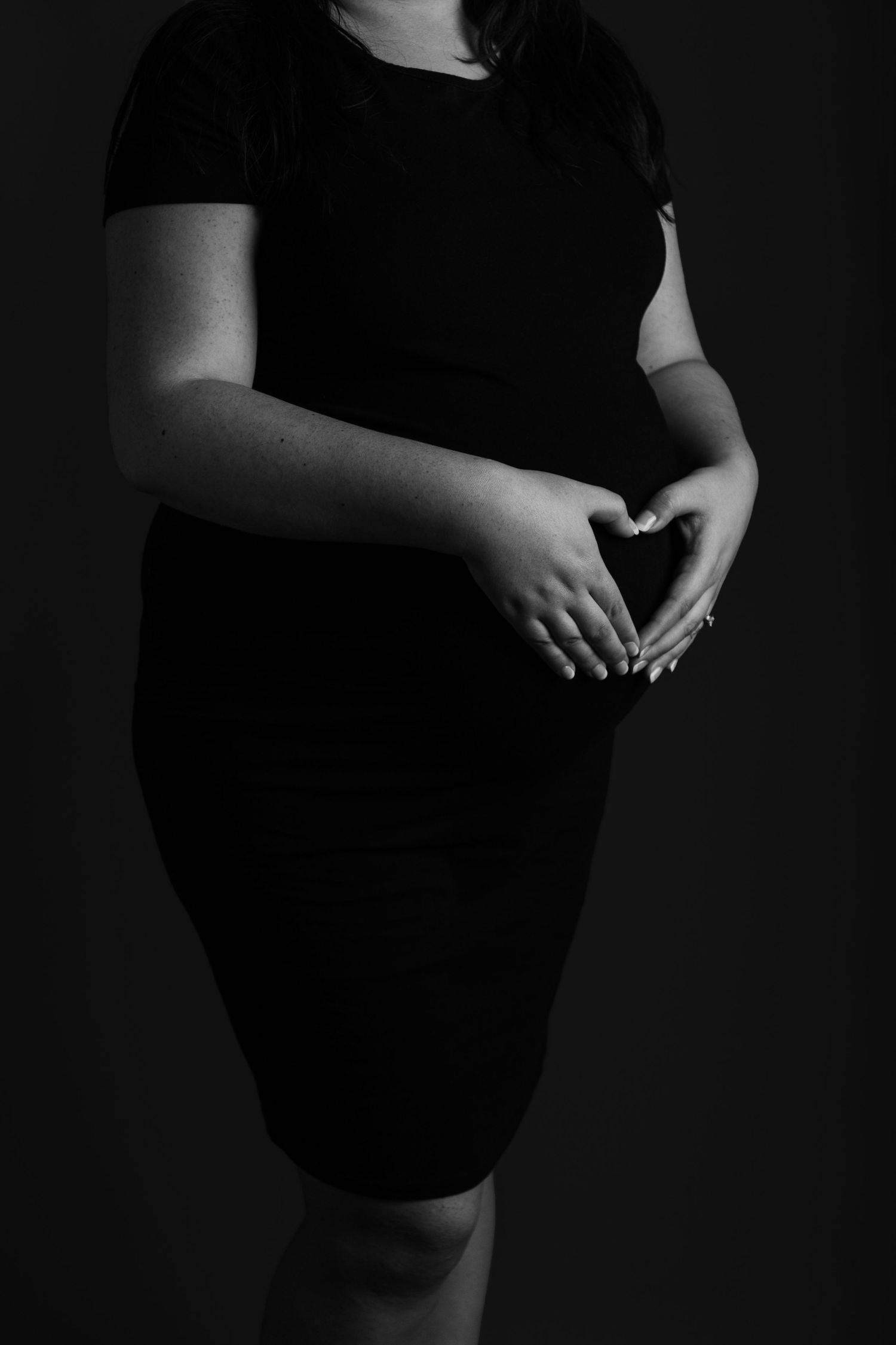 Artistic black and white maternity portraits with moody lighting.