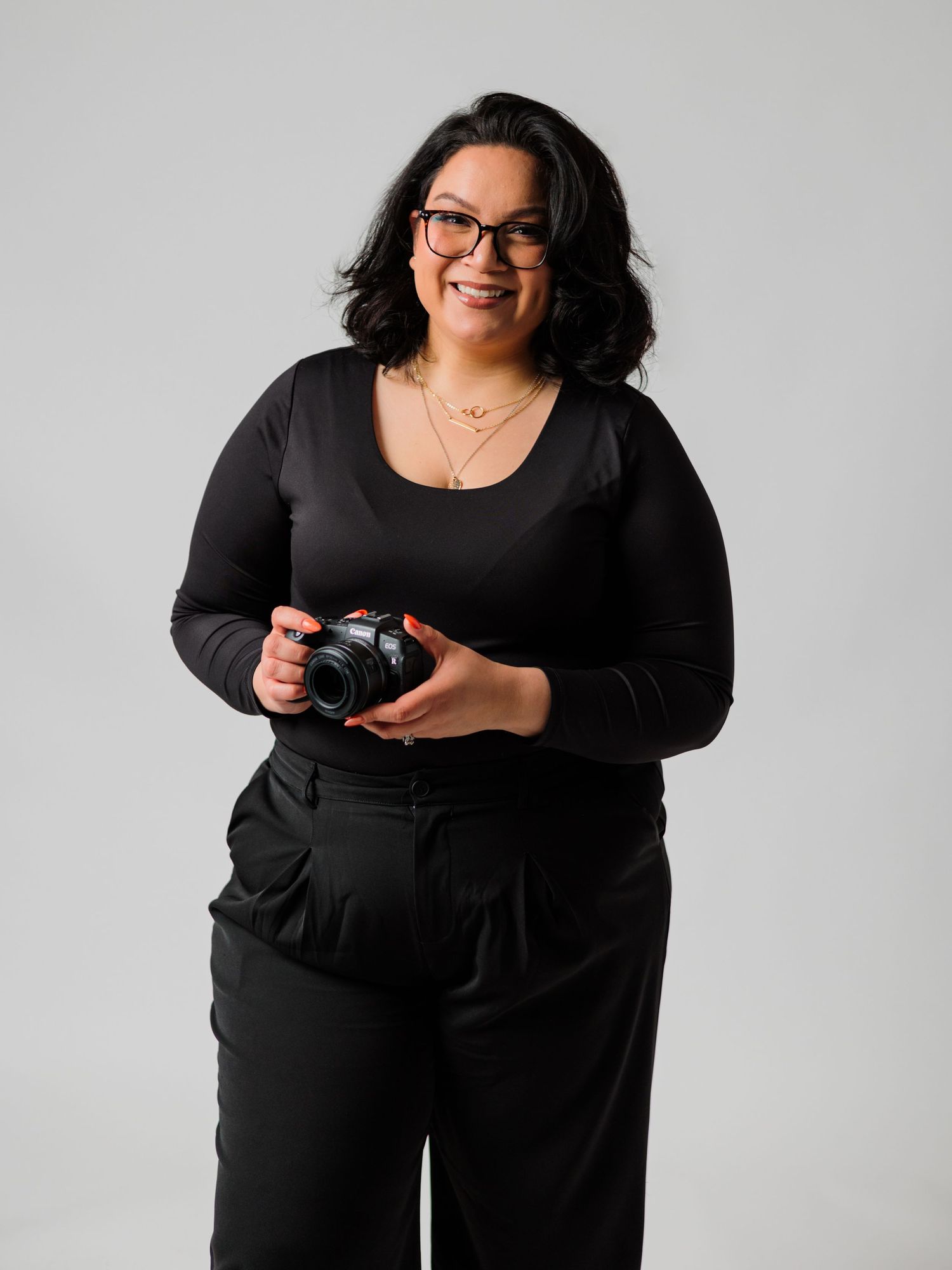 Professional photography series in black outfit showing playful poses with camera.