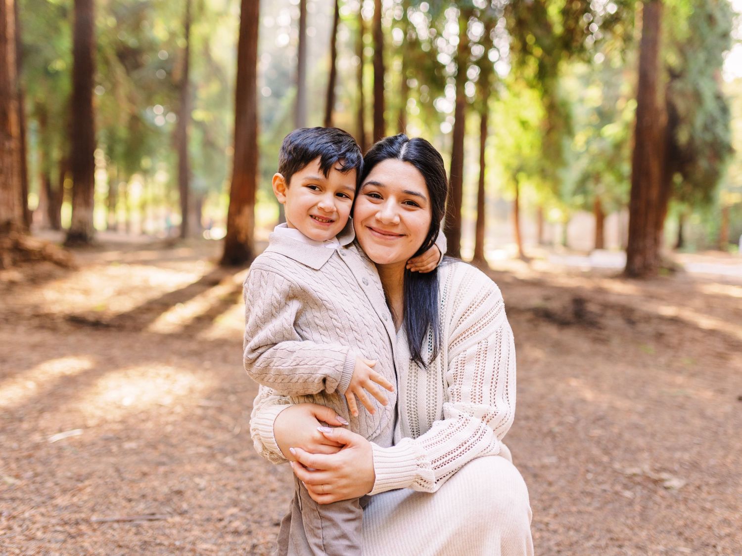 A tender moment captured between parent and child in a peaceful forest setting.