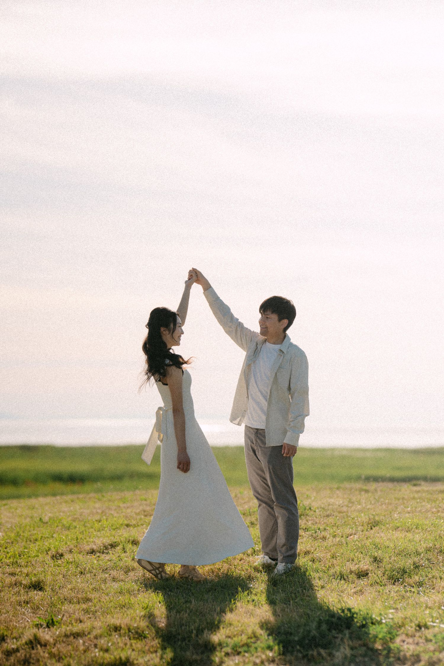 Couple dancing on hill at Terra Nova Park. Vancouver prewedding and engagement by Victor Li Photography.