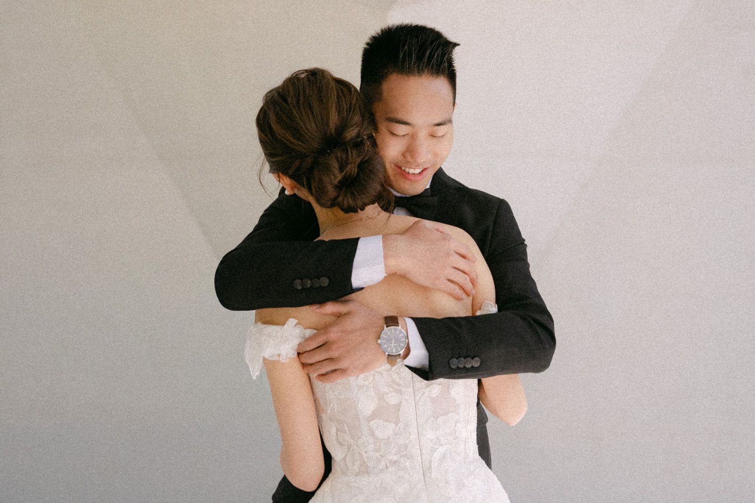 Groom embraces his bride at the first look. Vancouver wedding by Victor Li Photography.